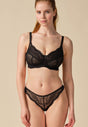 Full-body view of a women model wearing Gossard black microfibre Thong